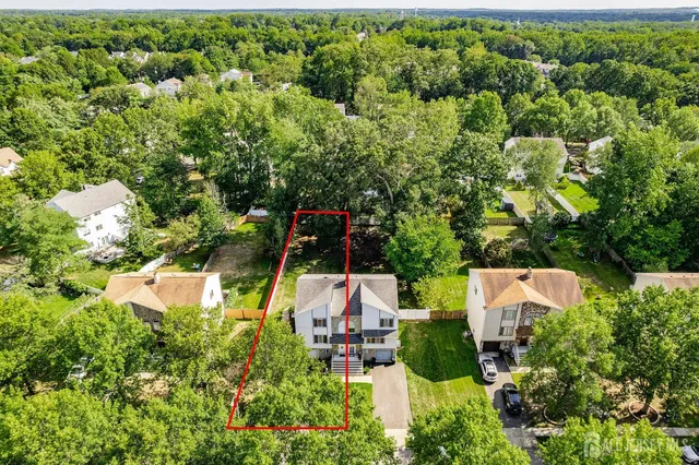 an aerial view of a house with swimming pool and garden