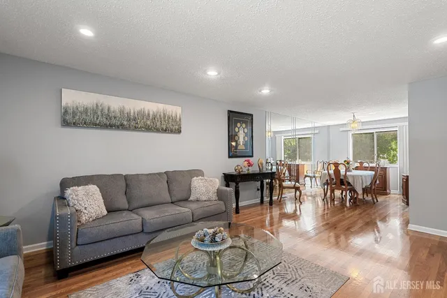 a living room with furniture and a dining table with wooden floor