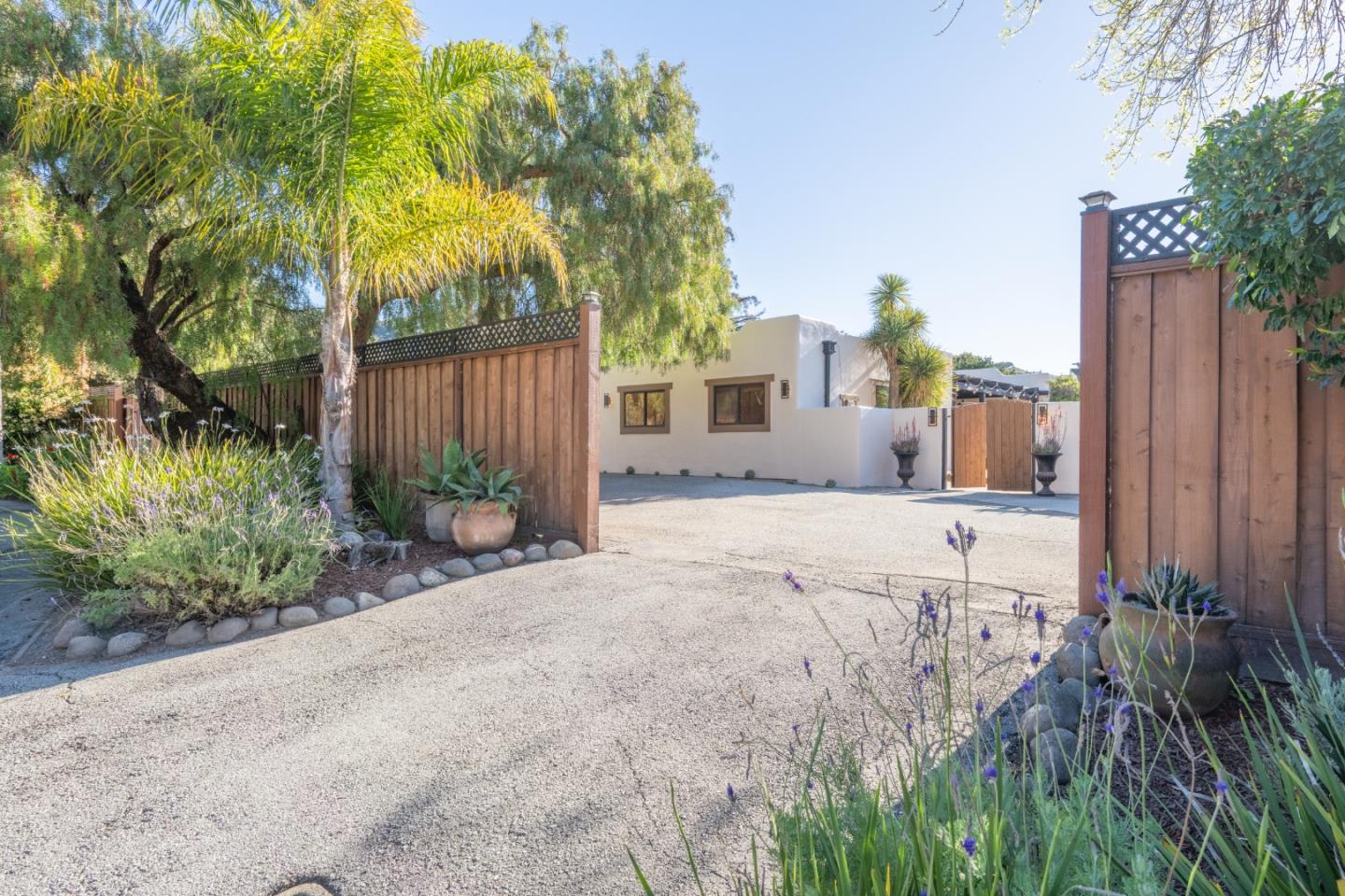 19 El Caminito Road Carmel Valley, CA 93924 - Photo 34 of 50 a view of a house with a small yard and a large tree