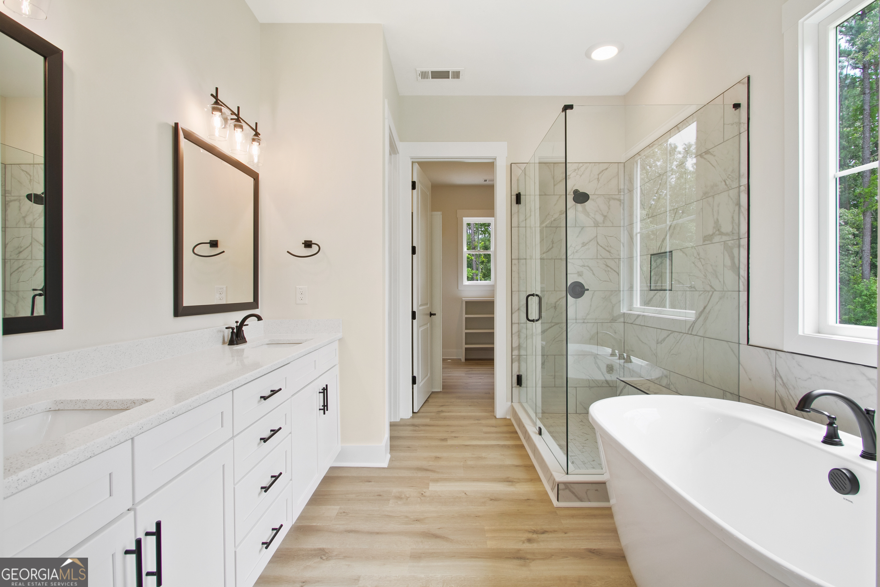 312 Clover Pass Forsyth, GA 31029 - Photo 20 of 22 a spacious bathroom with double vanity sinks a large mirror and a shower