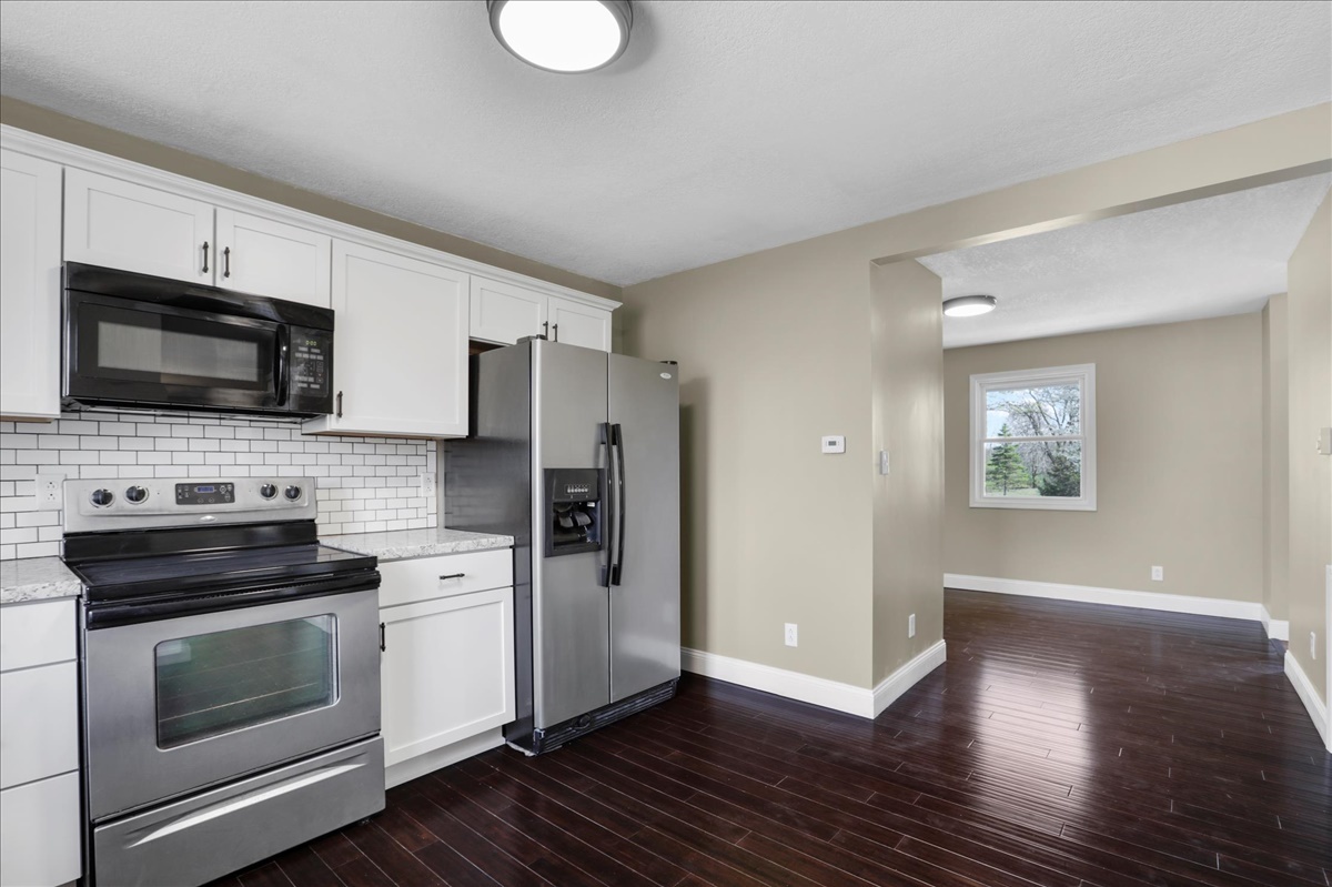 17105 Clinton Road Danville, IL 61834 - Photo 11 of 31 a kitchen with a refrigerator stove and wooden floor