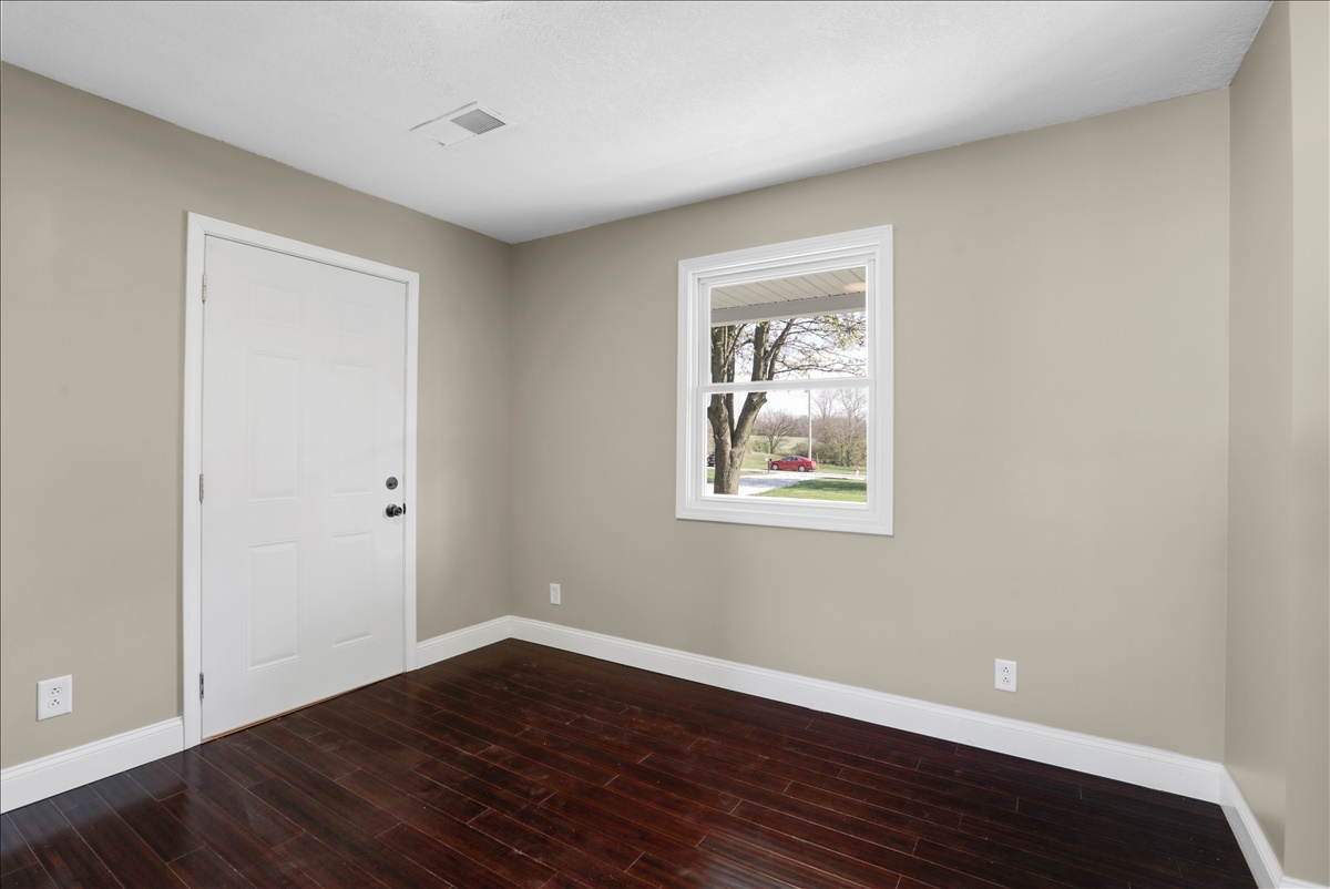 17105 Clinton Road Danville, IL 61834 - Photo 13 of 31 a view of an empty room with wooden floor and a window