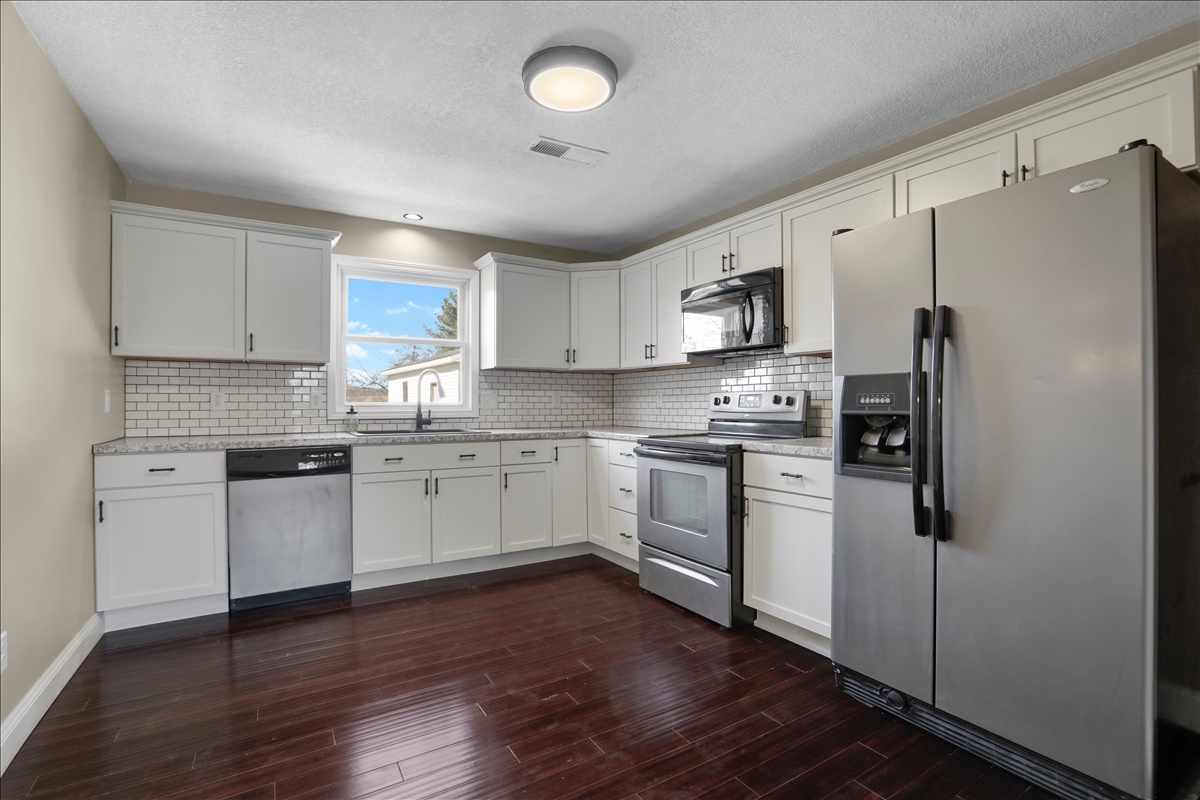 17105 Clinton Road Danville, IL 61834 - Photo 10 of 31 a kitchen with a refrigerator cabinets and wooden floor