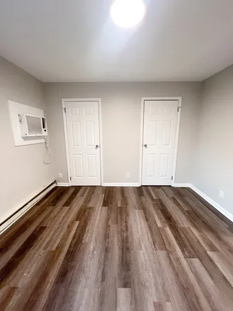 a view of a room with wooden floor and window
