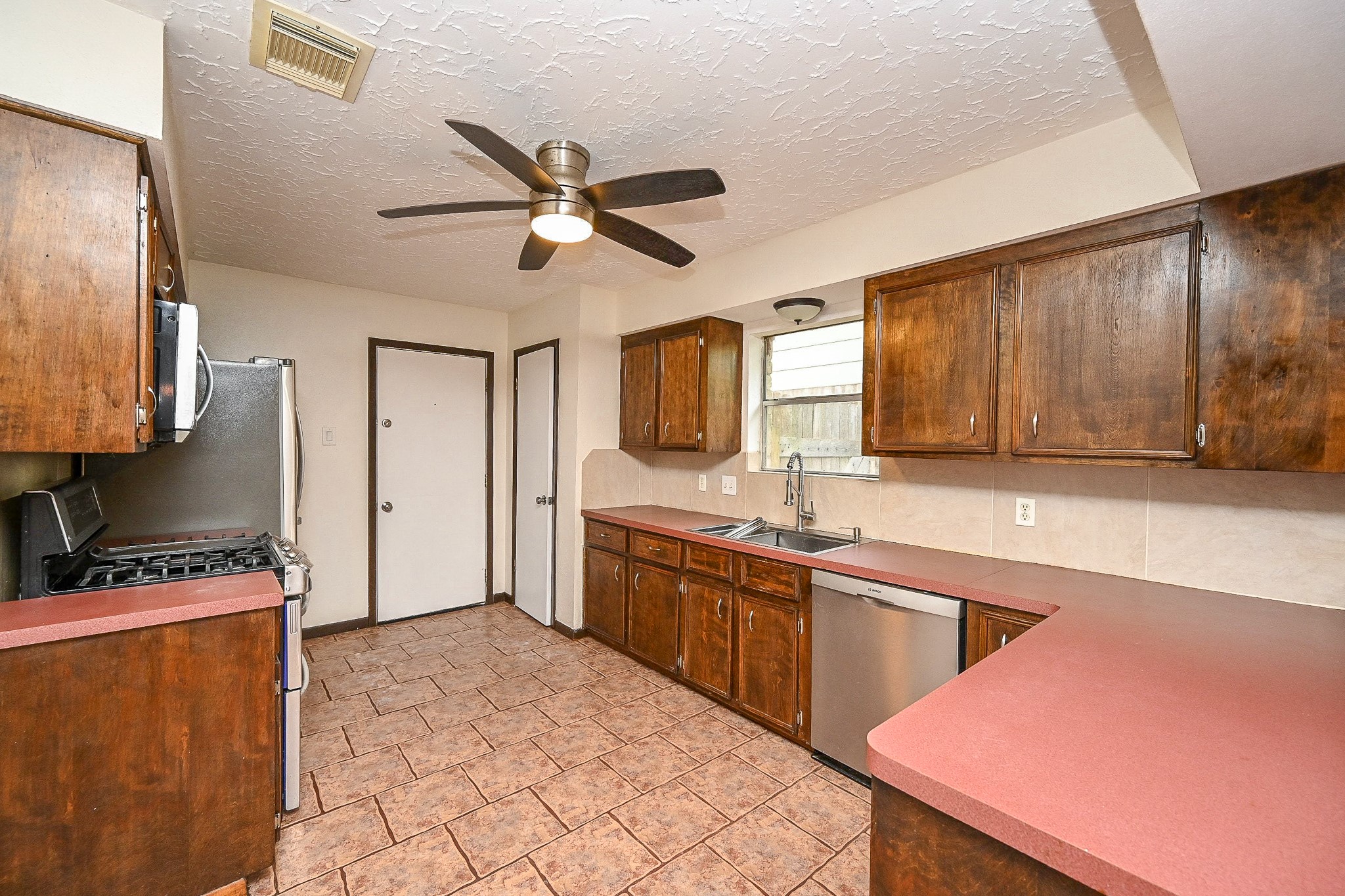 23814 Spring Gum Drive Spring, TX 77373 - Photo 4 of 21 a kitchen with stainless steel appliances kitchen island granite countertop a sink and cabinets
