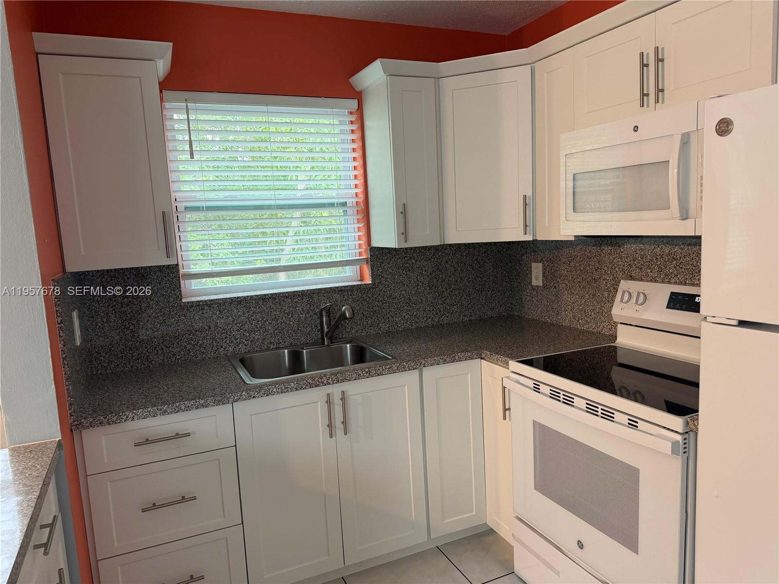 1301 North 12th Court, Unit 4B Hollywood, FL 33019 - Photo 11 of 27 a kitchen with granite countertop white cabinets and white appliances