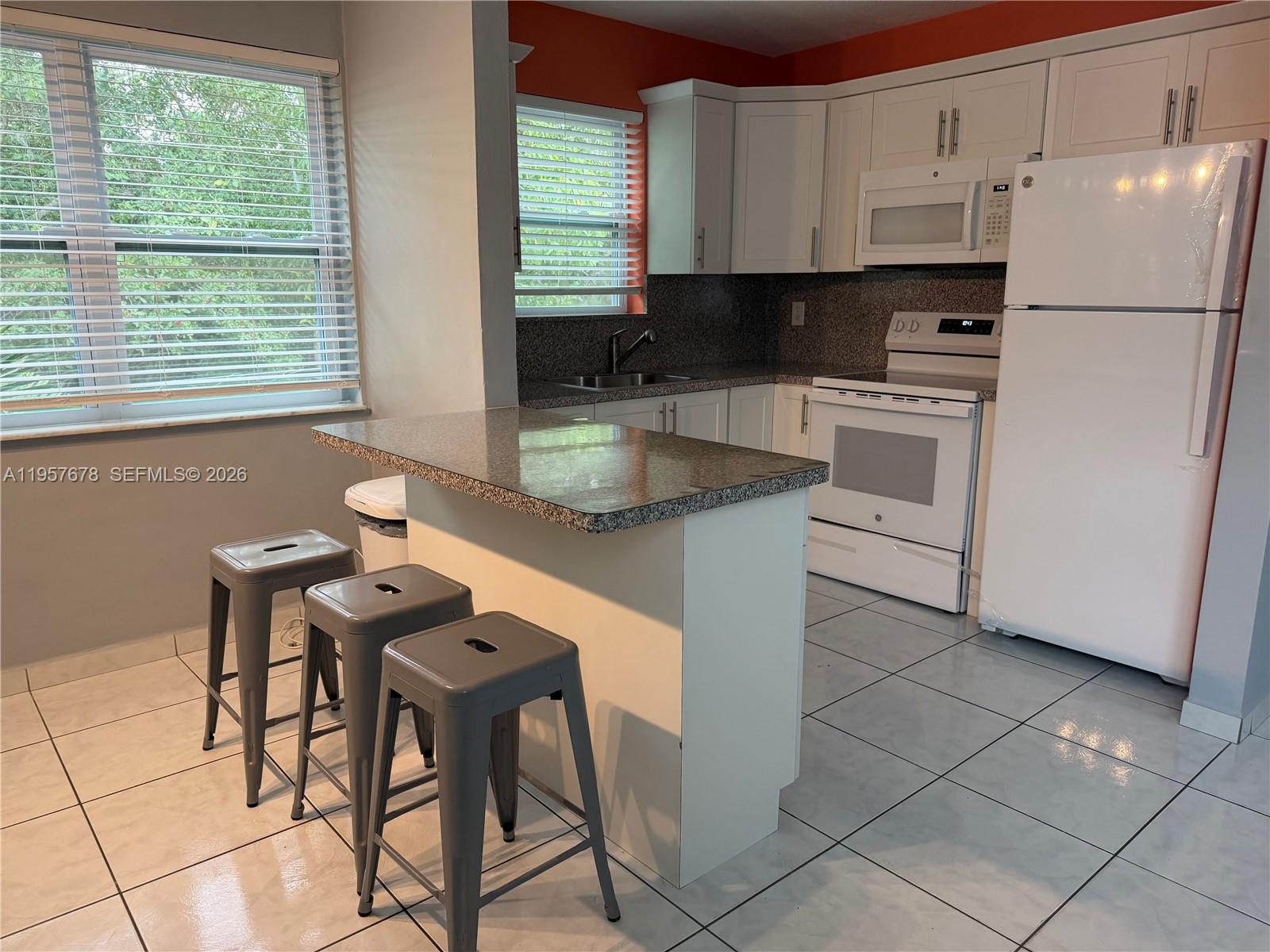 1301 North 12th Court, Unit 4B Hollywood, FL 33019 - Photo 15 of 27 a kitchen with a white cabinets and white appliances
