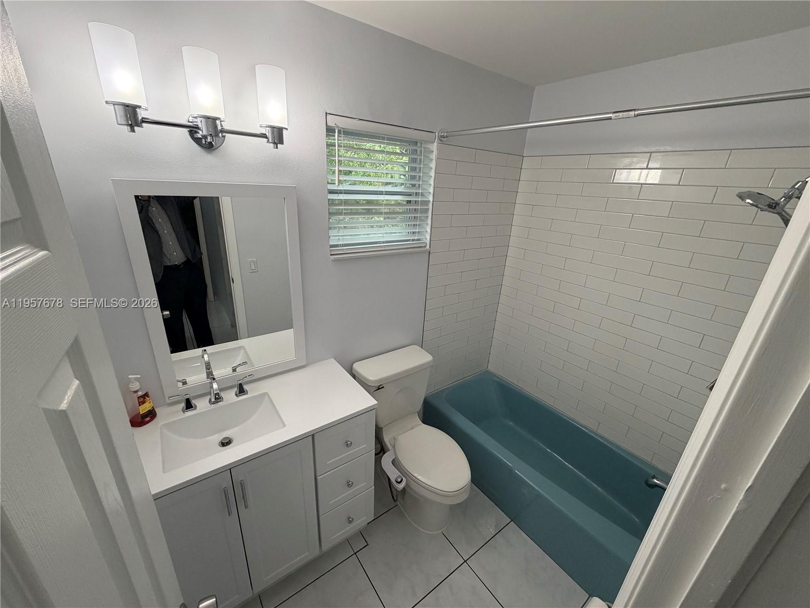 1301 North 12th Court, Unit 4B Hollywood, FL 33019 - Photo 17 of 27 a bathroom with a sink a toilet a mirror and shower