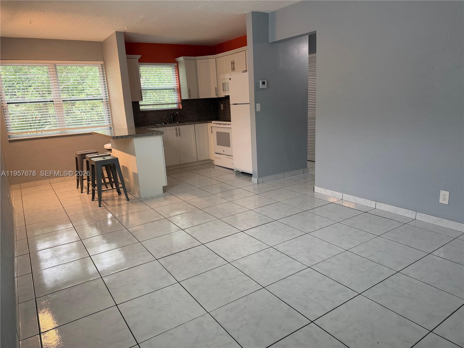 1301 North 12th Court, Unit 4B Hollywood, FL 33019 - Photo 5 of 27 a kitchen with granite countertop a sink cabinets and window