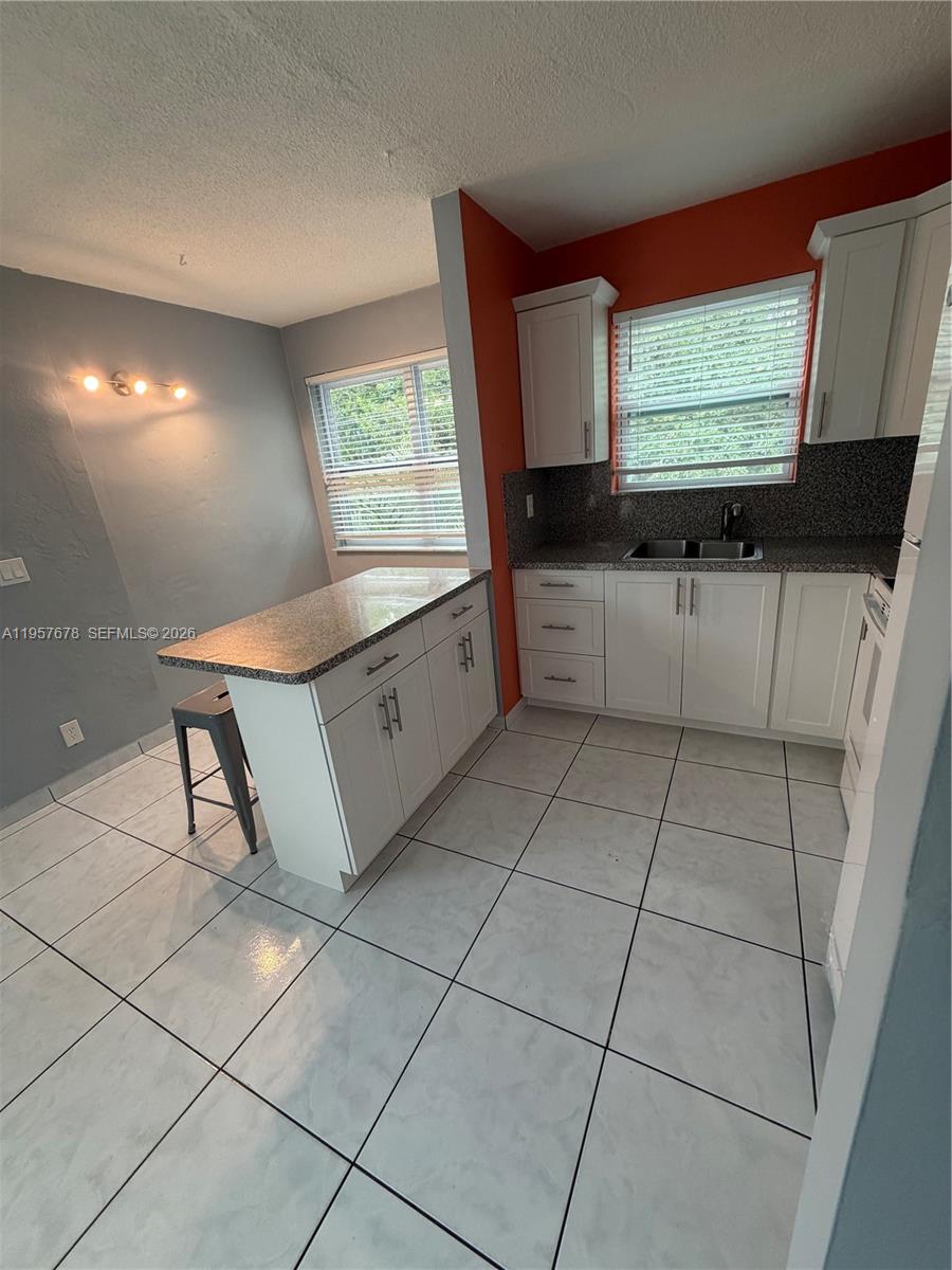 1301 North 12th Court, Unit 4B Hollywood, FL 33019 - Photo 10 of 27 a kitchen with stainless steel appliances a sink a stove a microwave a counter top and cabinets