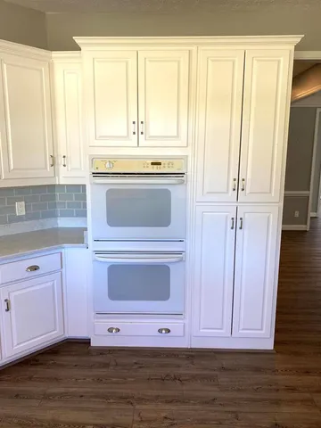 a kitchen with stainless steel appliances granite countertop white cabinets and sink