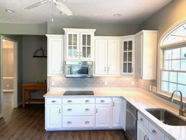 a kitchen with stainless steel appliances granite countertop a sink and dishwasher stove with wooden floor