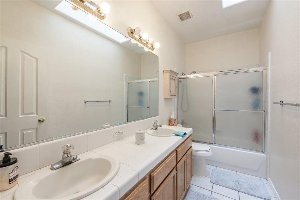 3159 Cedar Creek Lane Madera, CA 93637 - Photo 19 of 37 a bathroom with a granite countertop sink toilet and shower