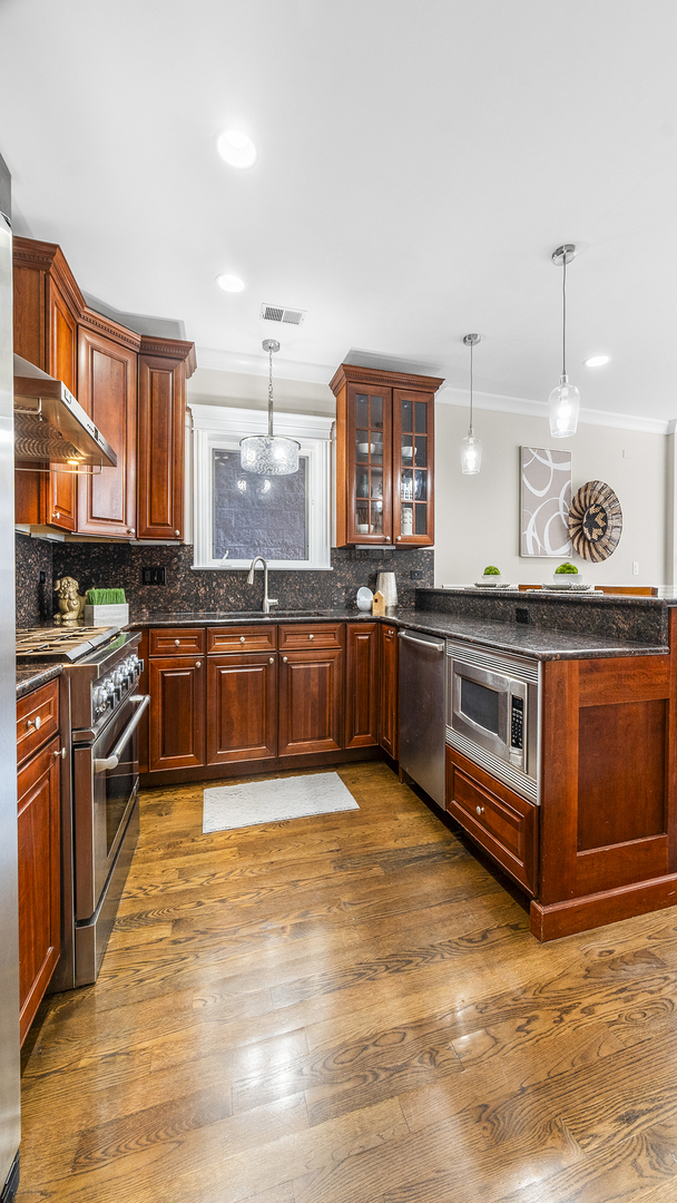912 West Fletcher Street, Unit 2 Chicago, IL 60657 - Photo 14 of 29 a large kitchen with stainless steel appliances granite countertop a stove and cabinets