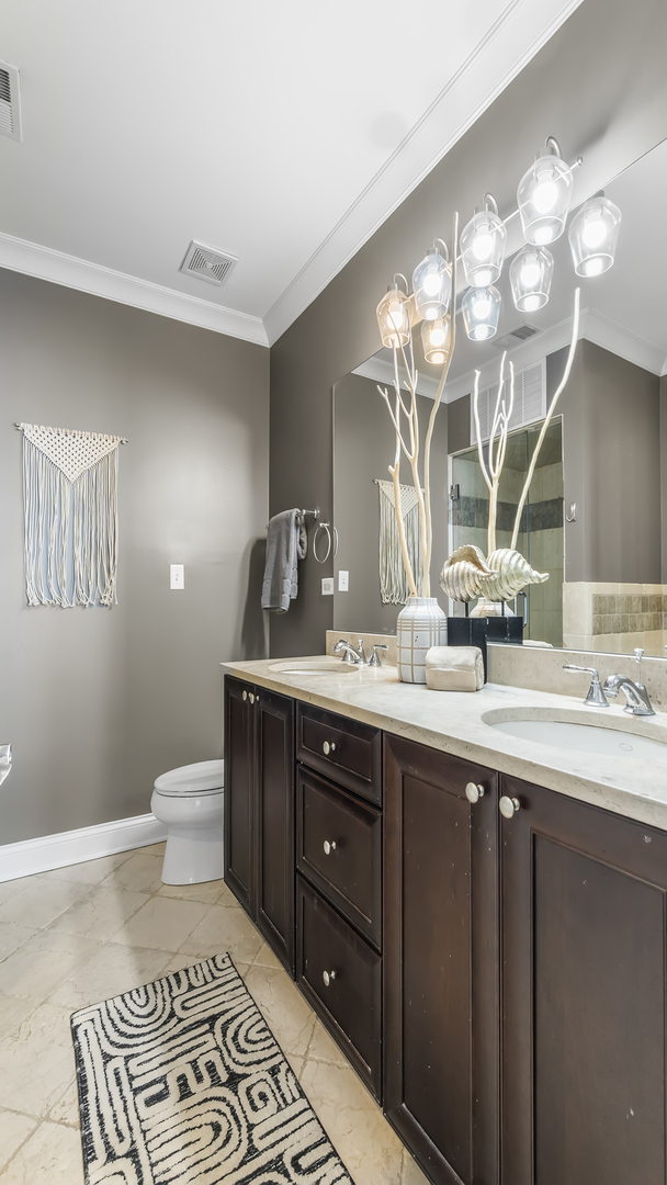 912 West Fletcher Street, Unit 2 Chicago, IL 60657 - Photo 24 of 29 a bathroom with a double vanity sink and a mirror