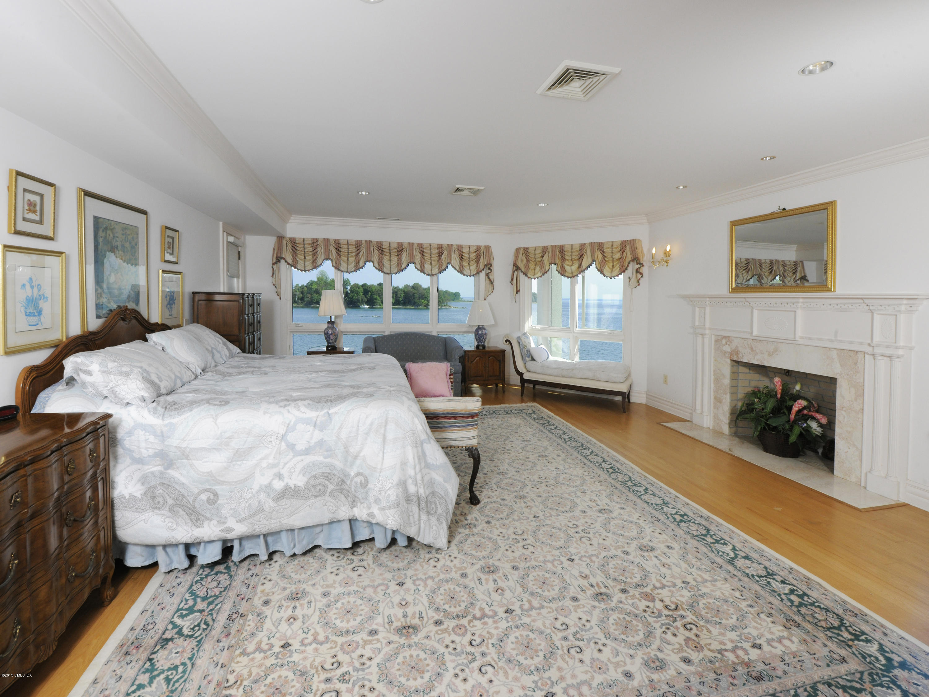 71 Byram Shore Road Greenwich, CT 06830 - Photo 21 of 32 a bedroom with a bed and a fireplace