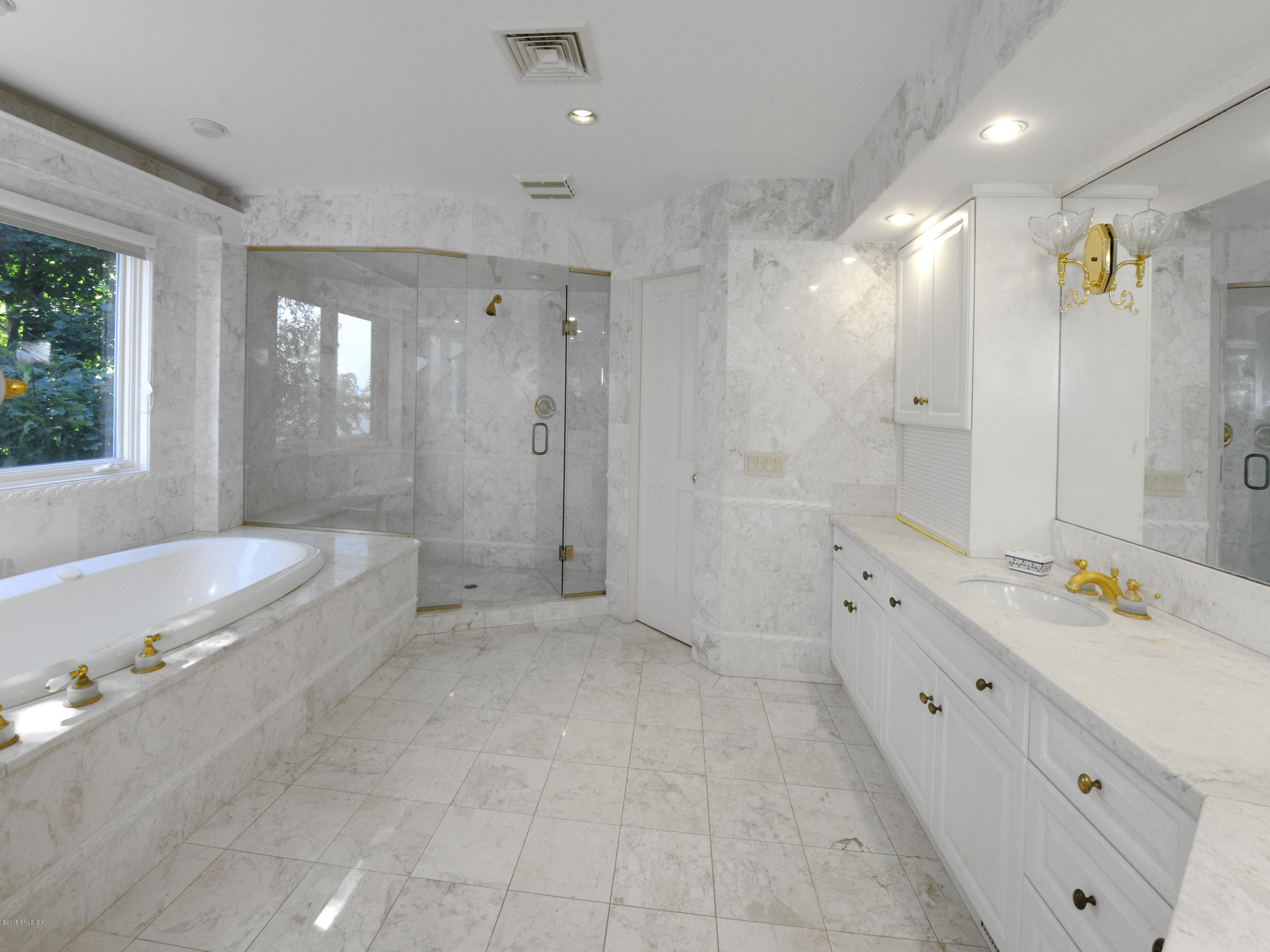71 Byram Shore Road Greenwich, CT 06830 - Photo 22 of 32 a spacious bathroom with a double vanity sink a large mirror a bathtub and shower