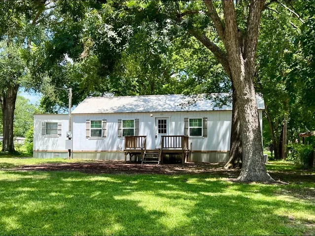 a view of a house with backyard and a tree