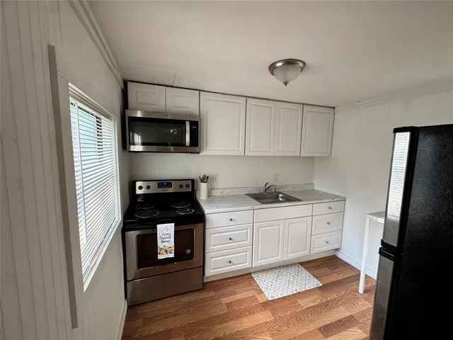 a kitchen with stainless steel appliances granite countertop a stove a refrigerator and a microwave