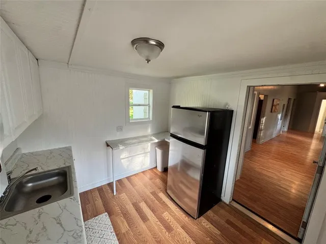 a hallway with wooden floor windows and a living room