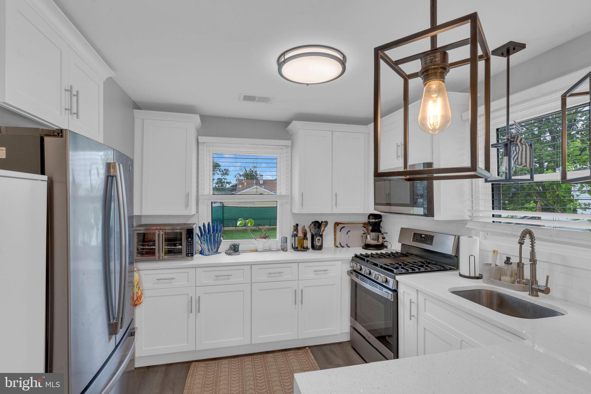 629 Polk Street Riverside, NJ 08075 - Photo 16 of 42 a kitchen with stainless steel appliances a sink cabinets and a window