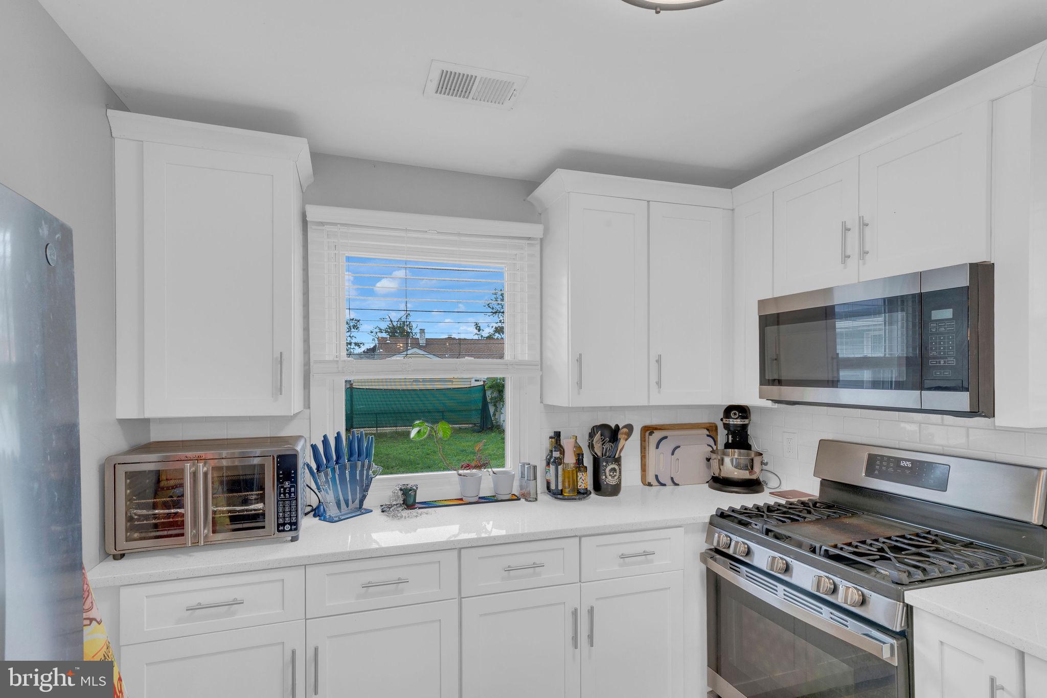 629 Polk Street Riverside, NJ 08075 - Photo 18 of 42 a kitchen with granite countertop stainless steel appliances a stove and a microwave