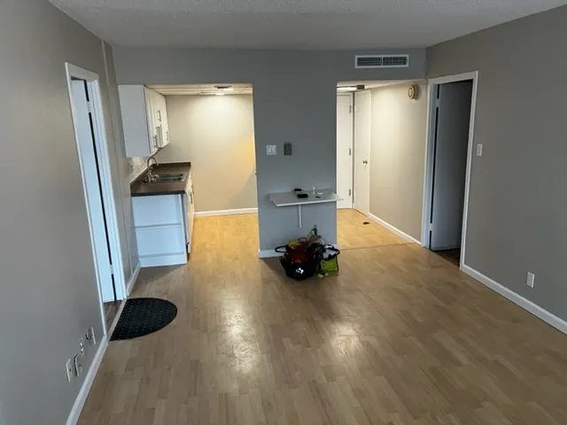 a view of an empty room and wooden floor