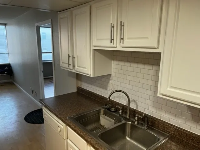 a kitchen with granite countertop a sink stainless steel appliances and cabinets