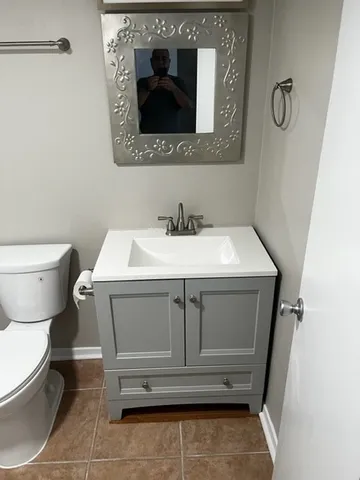 a bathroom with a toilet sink and mirror