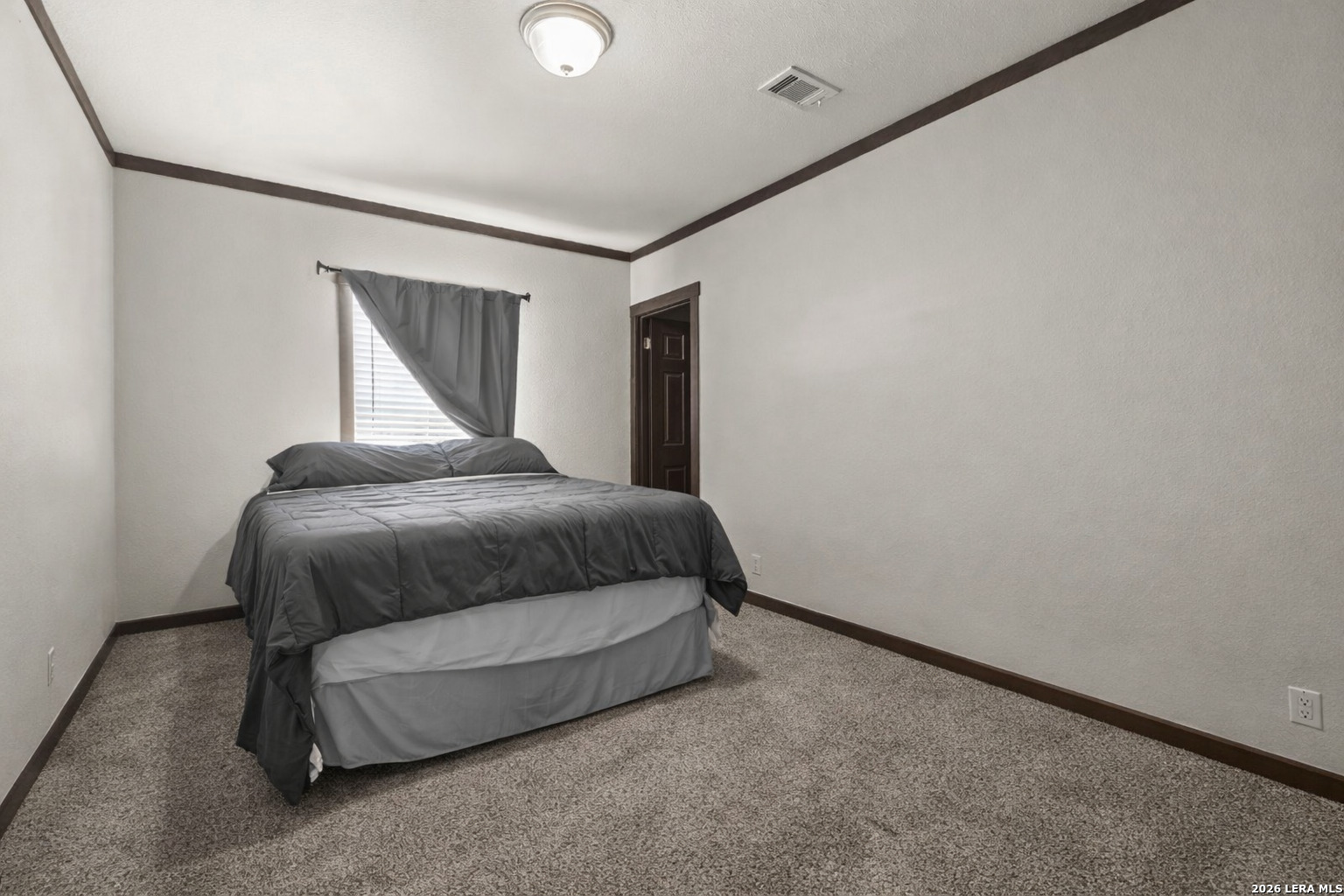 218 West 2nd Street Elmendorf, TX 78112 - Photo 5 of 13 a bedroom with a bed and a painting on the wall