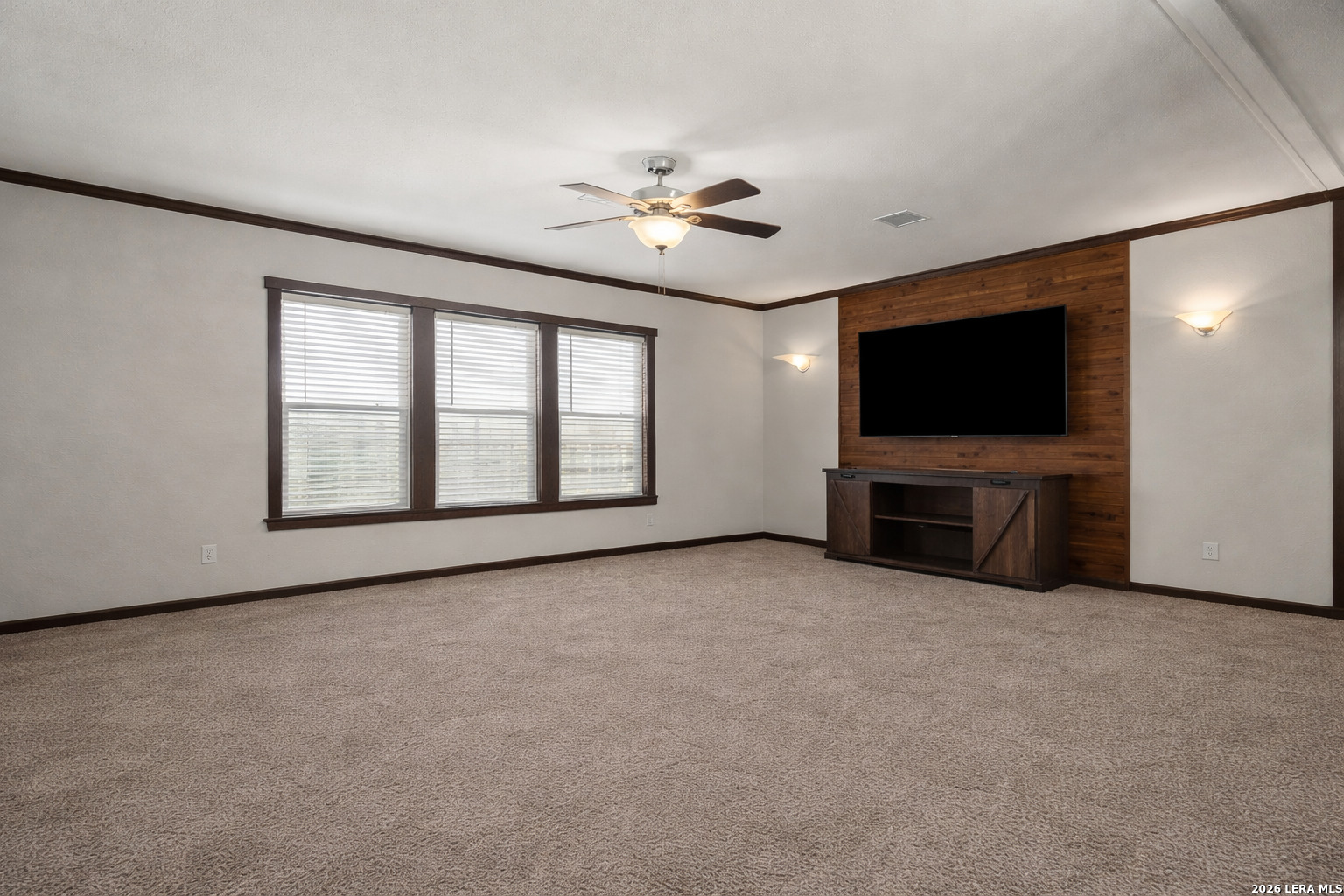 218 West 2nd Street Elmendorf, TX 78112 - Photo 6 of 13 an empty room with chandelier fan and windows