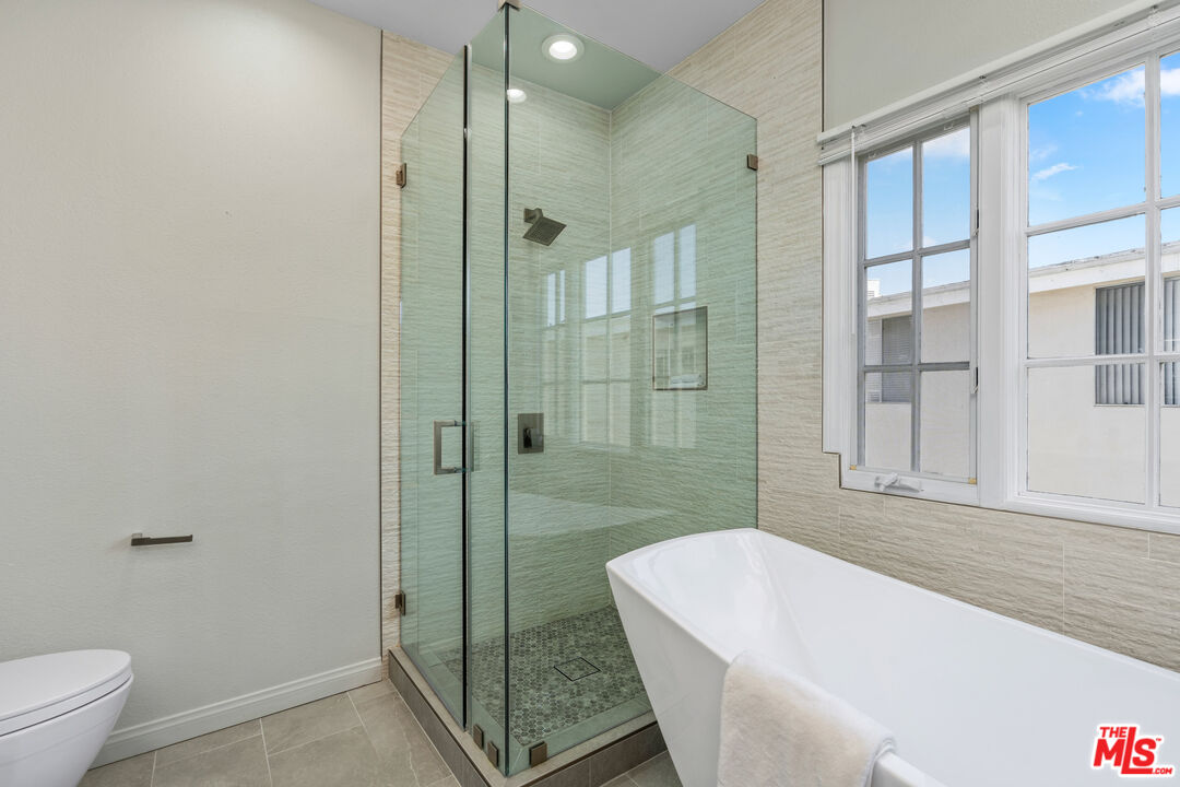 1663 Malcolm Avenue, Unit 103 Los Angeles, CA 90024 - Photo 25 of 45 a white bath tub sitting next to a toilet