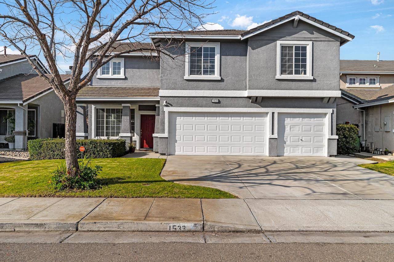 a front view of a house with a yard and garage