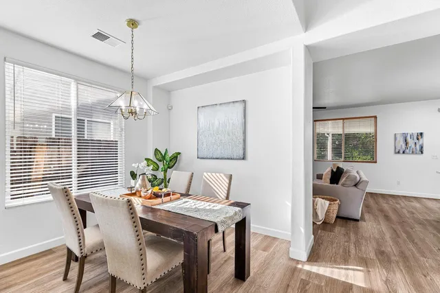 a living room kitchen with stainless steel appliances kitchen island granite countertop a dining table and chairs
