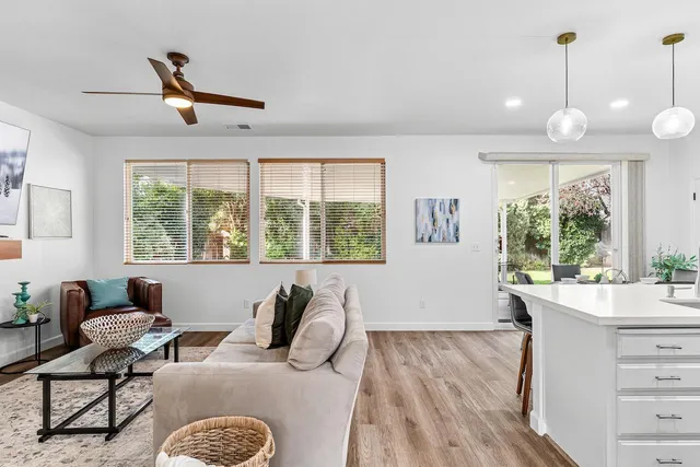 a kitchen with a dining table chairs refrigerator and white cabinets