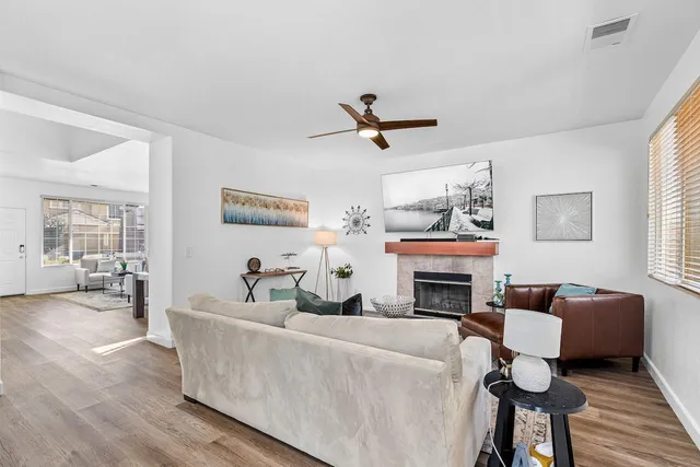 a open kitchen with a sink a stove and chairs with wooden floor