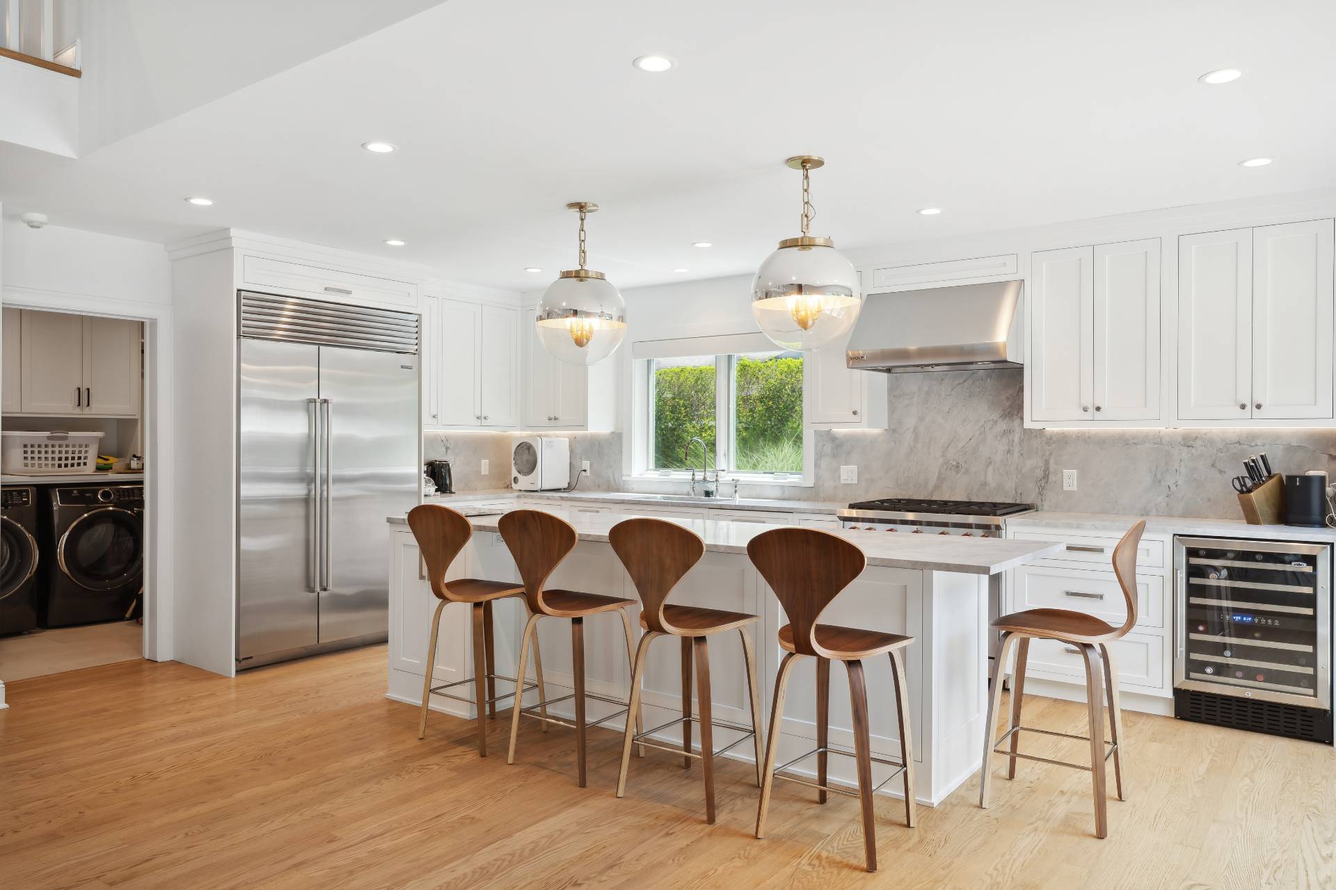 31 East Gate Road Wainscott, NY 11975 - Photo 2 of 20 a kitchen with stainless steel appliances granite countertop a stove a refrigerator a oven a sink with island chairs and wooden floor