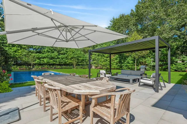 a view of a patio with a table and chairs under an umbrella