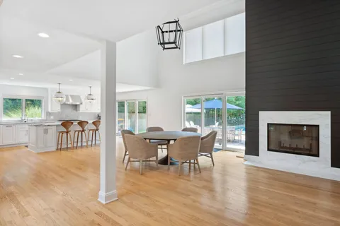 a view of a dining room with furniture a fireplace and wooden floor