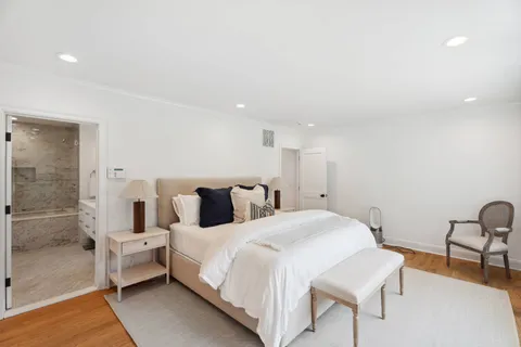 a spacious bedroom with a bed and a chair