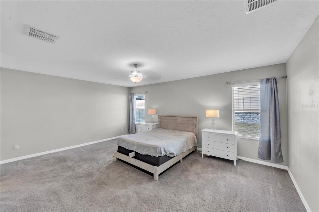 4215 Hanover Drive New Port Richey, FL 34653 - Photo 13 of 46 a bedroom with a bed and a lamp