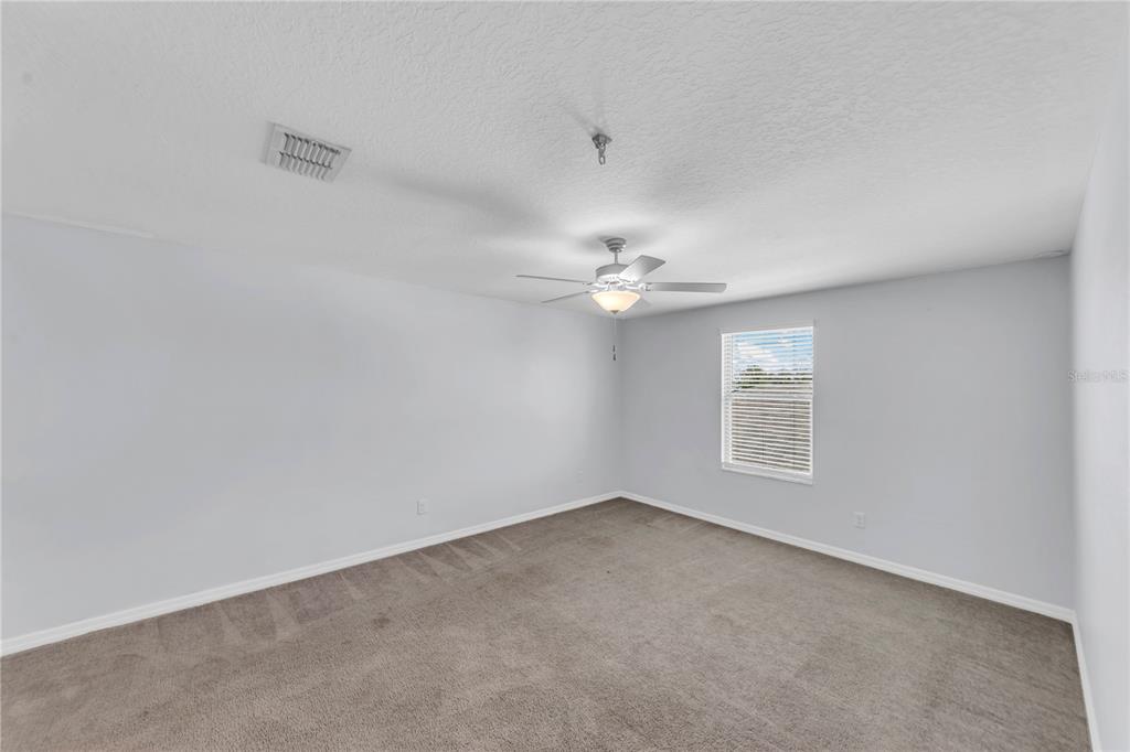 4215 Hanover Drive New Port Richey, FL 34653 - Photo 22 of 46 an empty room with a window and ceiling fan