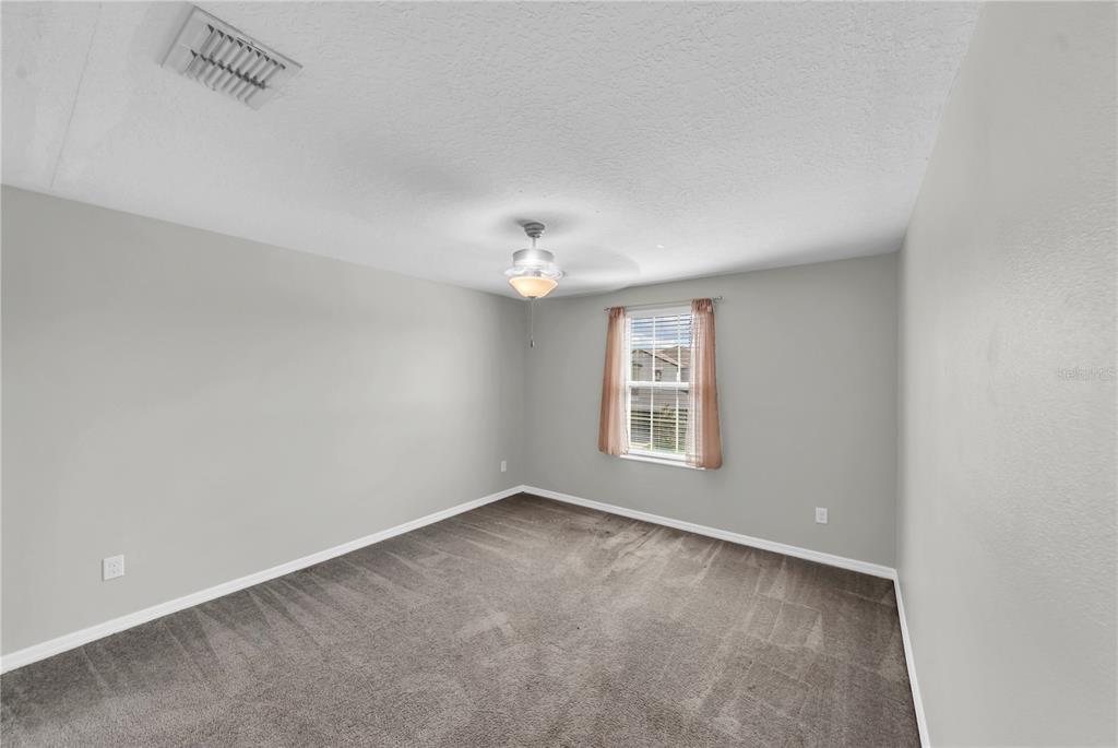 4215 Hanover Drive New Port Richey, FL 34653 - Photo 24 of 46 an empty room with a chandelier fan and windows