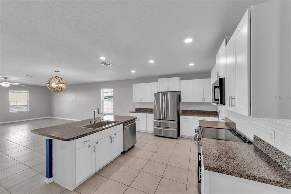 4215 Hanover Drive New Port Richey, FL 34653 - Photo 4 of 46 a kitchen with stainless steel appliances granite countertop a sink and a refrigerator