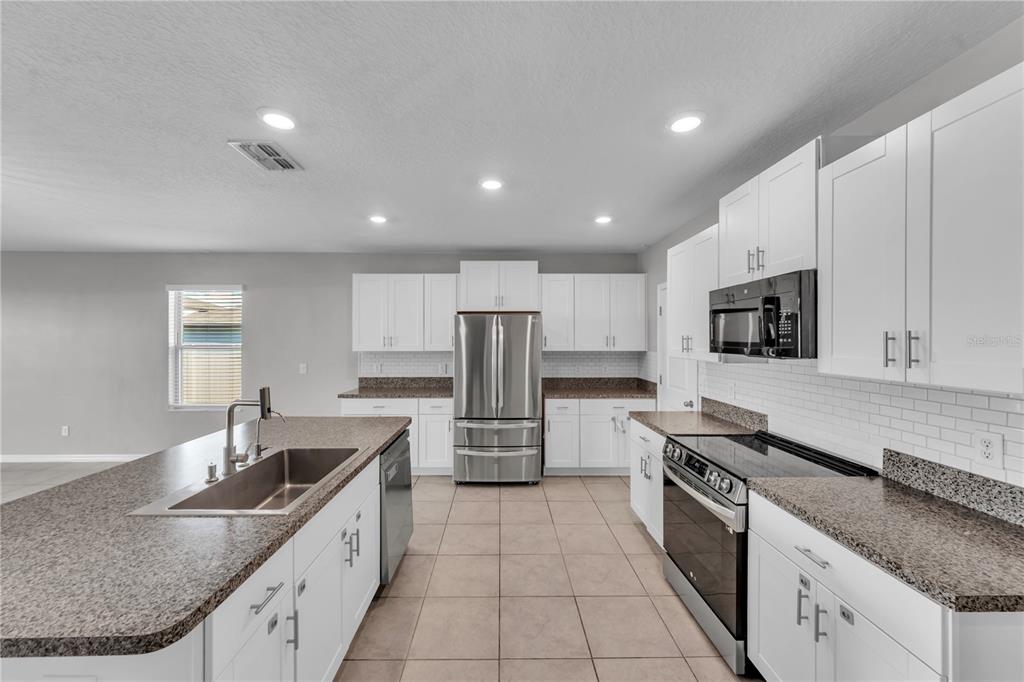 4215 Hanover Drive New Port Richey, FL 34653 - Photo 8 of 46 a kitchen with stainless steel appliances granite countertop a sink stove and refrigerator