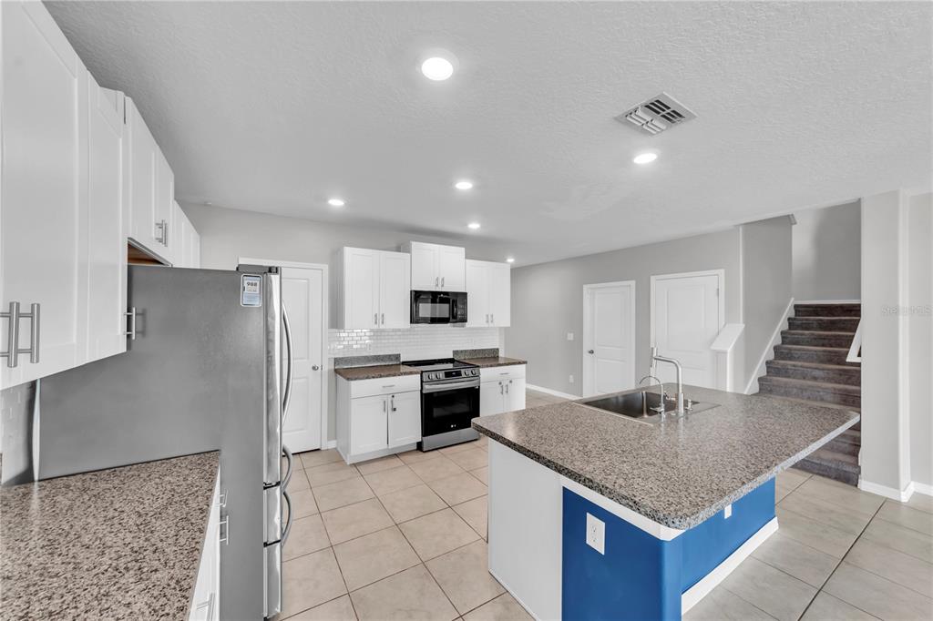 4215 Hanover Drive New Port Richey, FL 34653 - Photo 9 of 46 a kitchen with stainless steel appliances granite countertop a refrigerator and a stove top oven