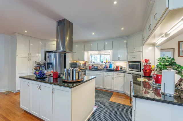 a kitchen filled with a white cabinets and chandelier