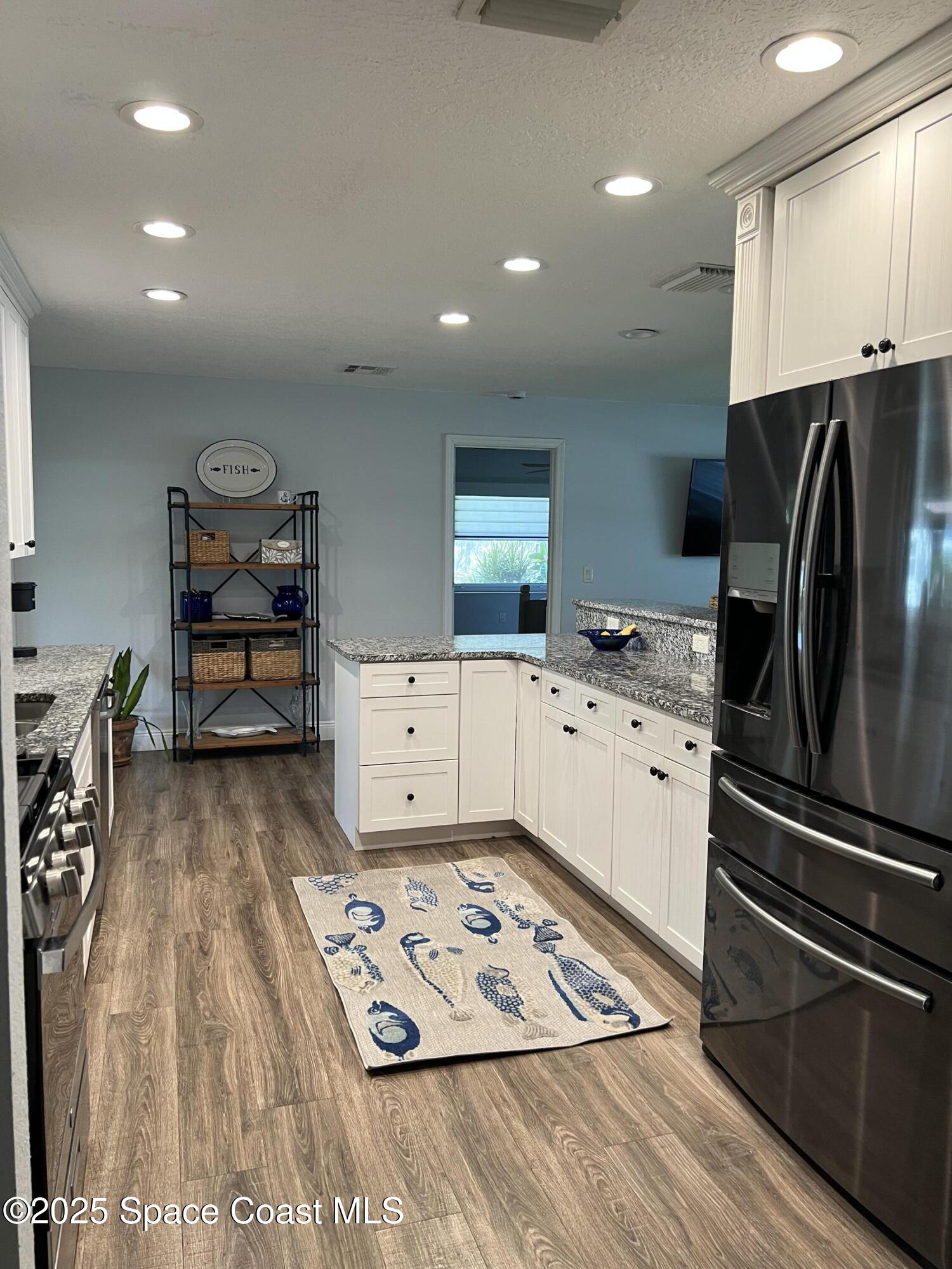821 Hanover Court Rockledge, FL 32955 - Photo 3 of 15 a kitchen with stainless steel appliances granite countertop a refrigerator and a stove top oven