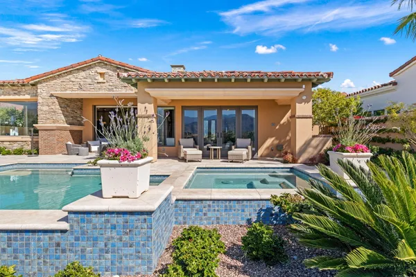 a view of a swimming pool and lounge chairs in back yard of the house