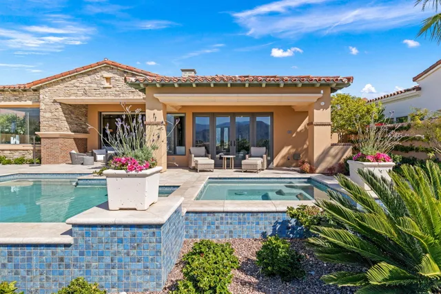 a view of a swimming pool and lounge chairs in back yard of the house